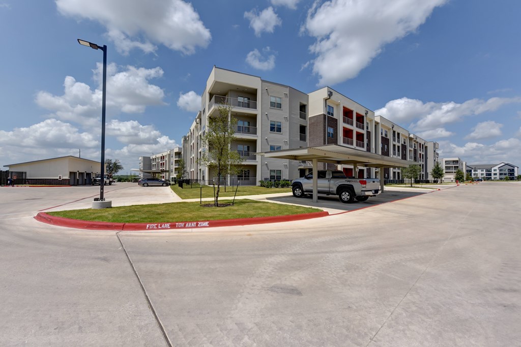 A parking lot with a building in the background and a sign that says "FIRST LINE TO AIR TIME".