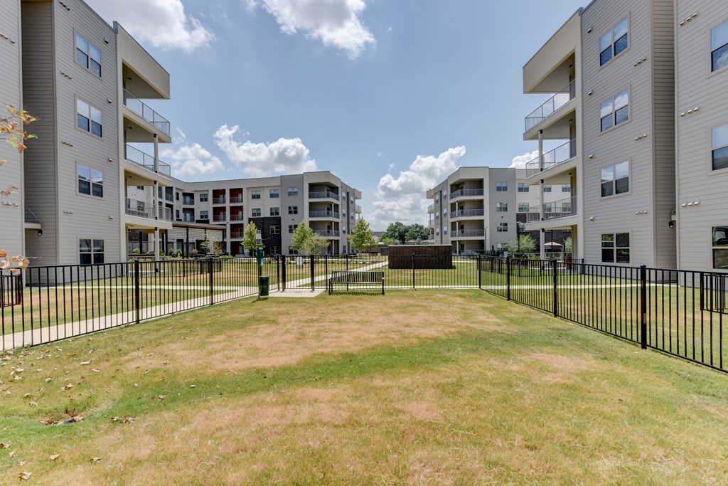 A grassy area in front of apartment buildings.