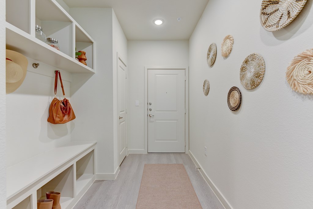 A hallway with a white door and wall decorations.