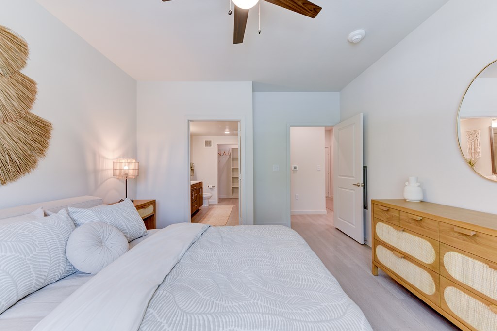 A bedroom with a large bed and a ceiling fan.
