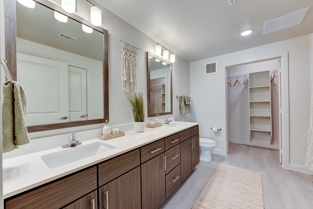 A bathroom with a sink, mirror, and towel rack.
