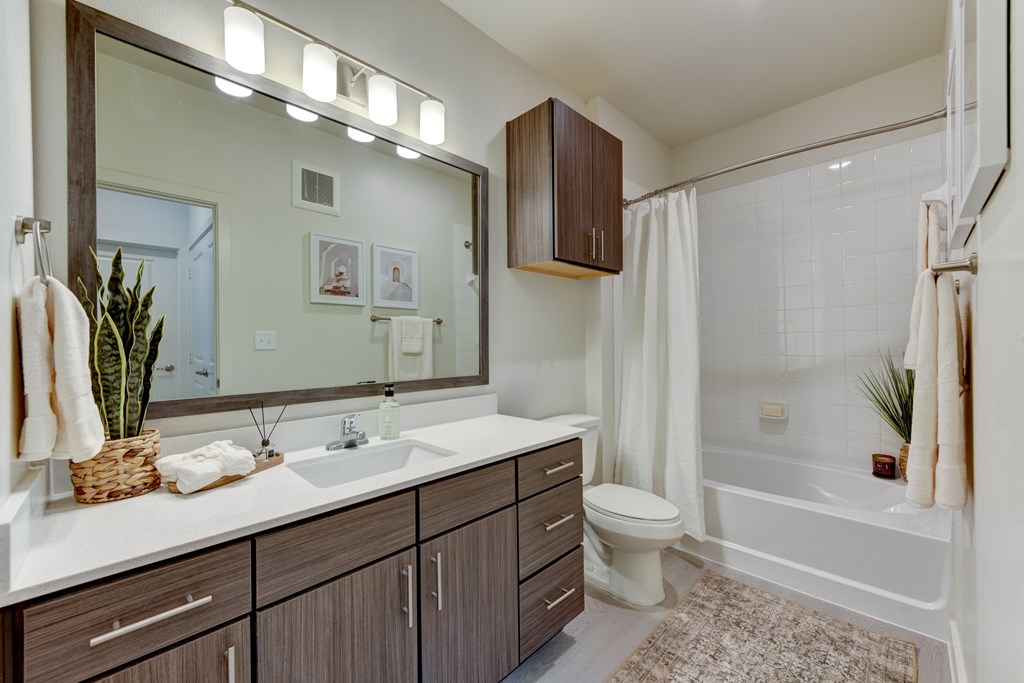 A bathroom with a white sink and a large mirror.