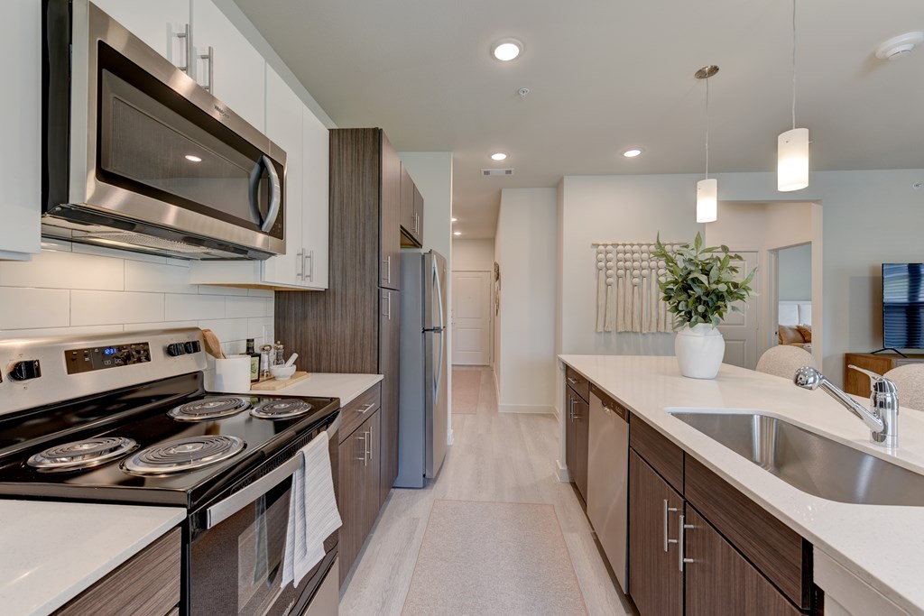 A modern kitchen with a stove top oven and a refrigerator.