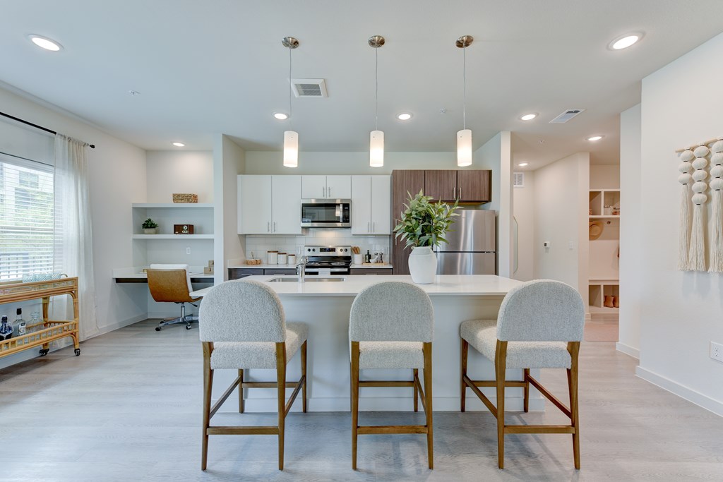 A modern kitchen with a dining table and chairs.