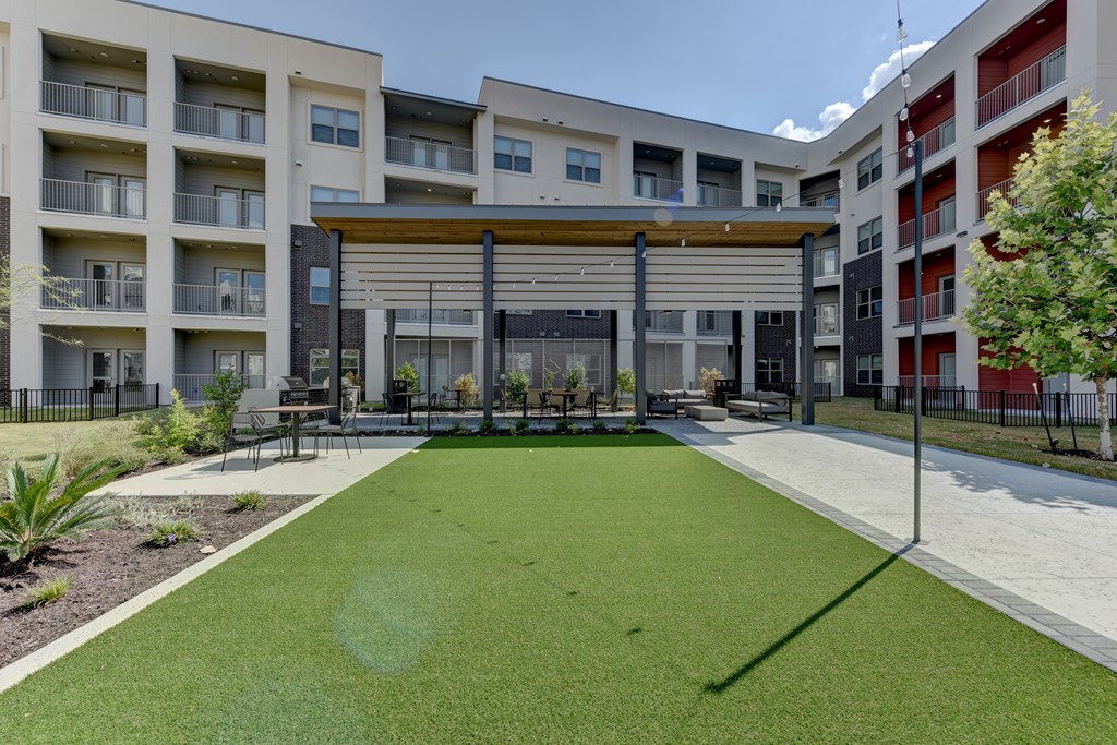 A grassy area in front of apartment buildings.