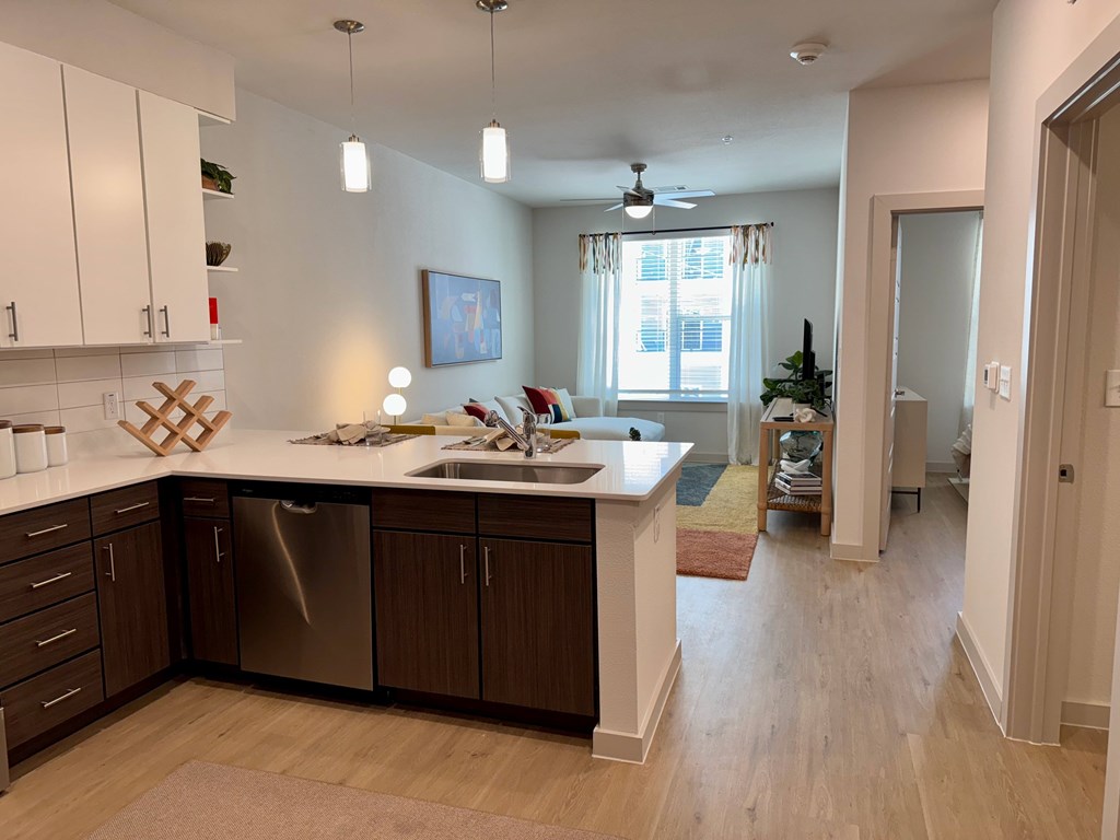 A kitchen with a white countertop and wooden cabinets.