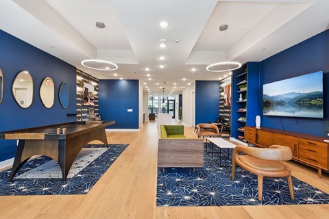 a living room with blue walls and a tv and a table and chairs
