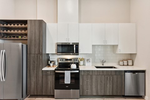 a modern kitchen with stainless steel appliances and white cabinets