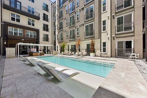 Outdoor pool courtyard surrounded by apartment buildings at Bridge at Windsor Park Apartments, Texas