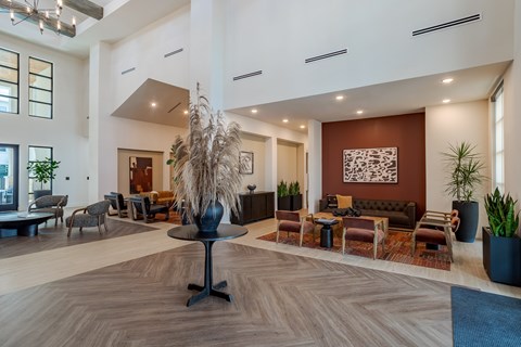 A large room with a wooden floor and a variety of seating options.
