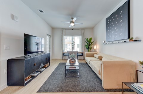 A living room with a large television and a sofa.