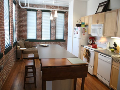 A kitchen with a table and chairs in front of a window.