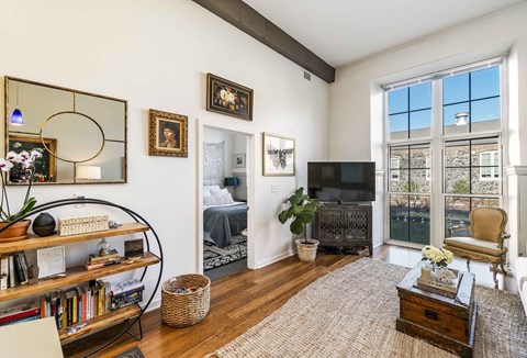 A living room with a large window and a flat screen TV.