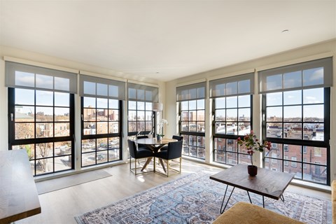 A living room with a view of the city through large windows.