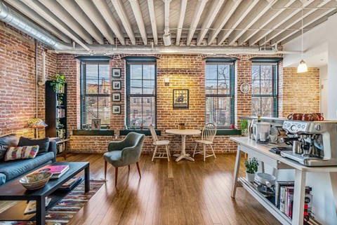 A living room with a brick wall and wooden floors.