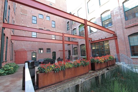 A red brick building with a metal railing and flower boxes.