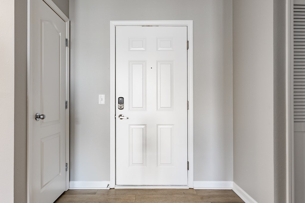 A white door with a black handle and lock in a room.