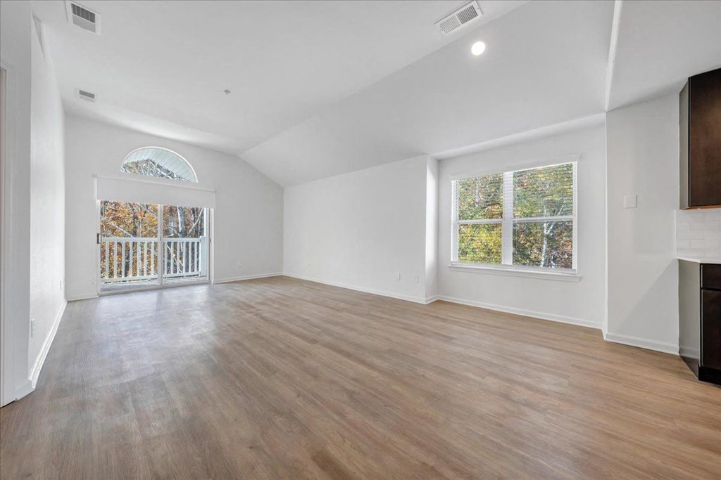 an empty living room with white walls and a sliding glass door at The Vinings Apartments, Virginia, 23234
