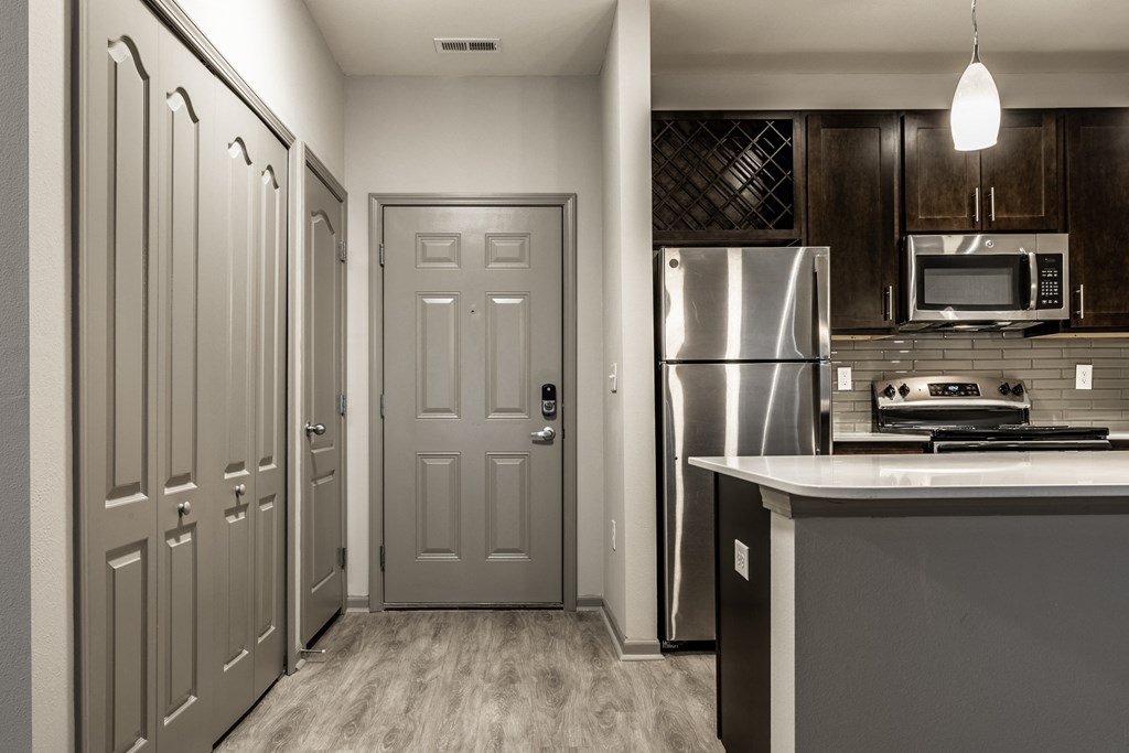 a kitchen with stainless steel appliances and a grey door Fisher, Indiana