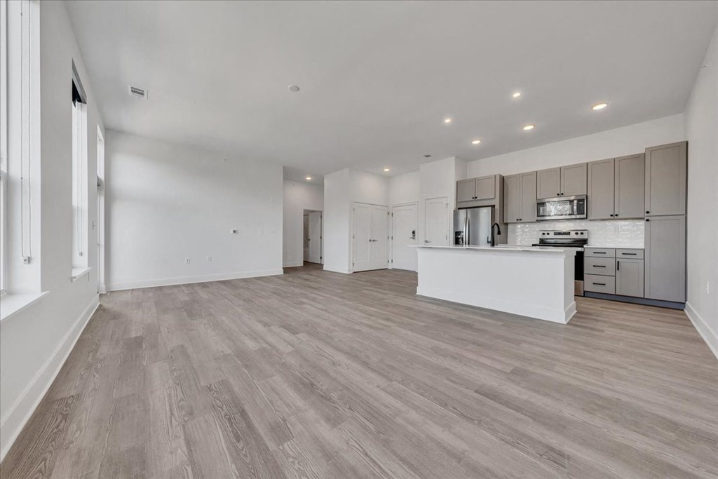 the living room and kitchen of a new home with a kitchen island and at Luxe 360 in Midlothian, Midlothian, 23114