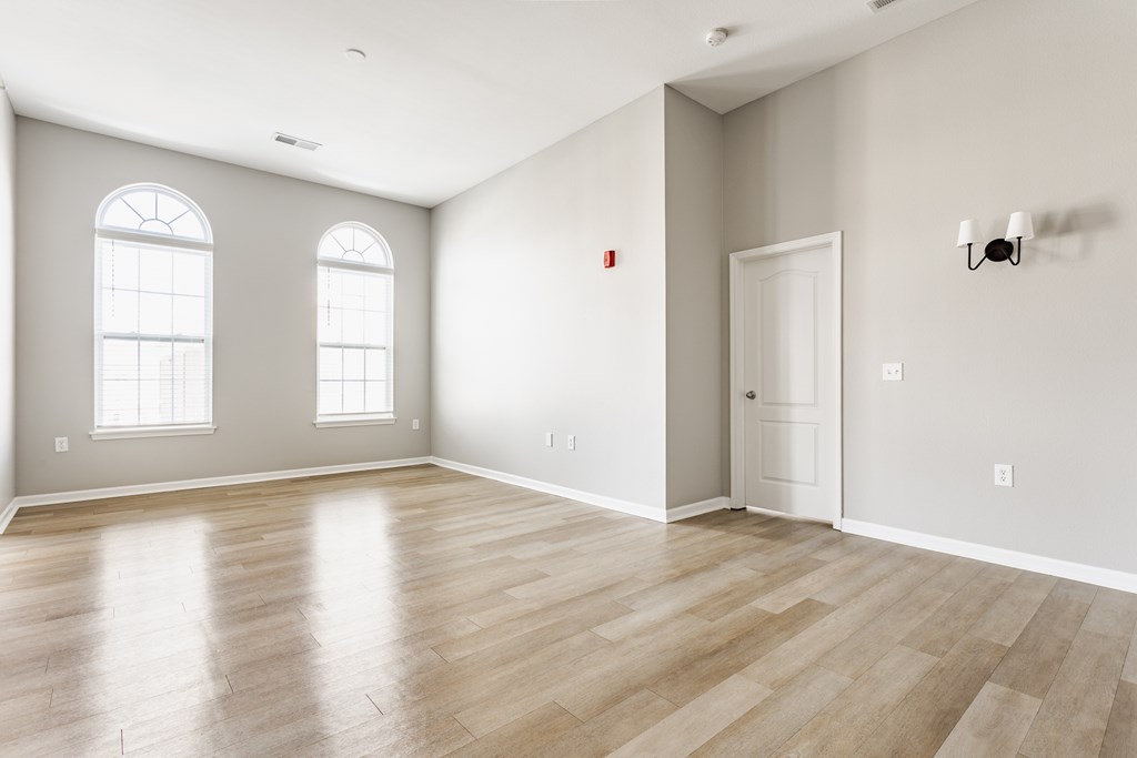 A room with wooden flooring and a white door.