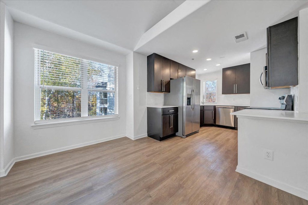 a kitchen and living room with a large window at The Vinings Apartments, Richmond