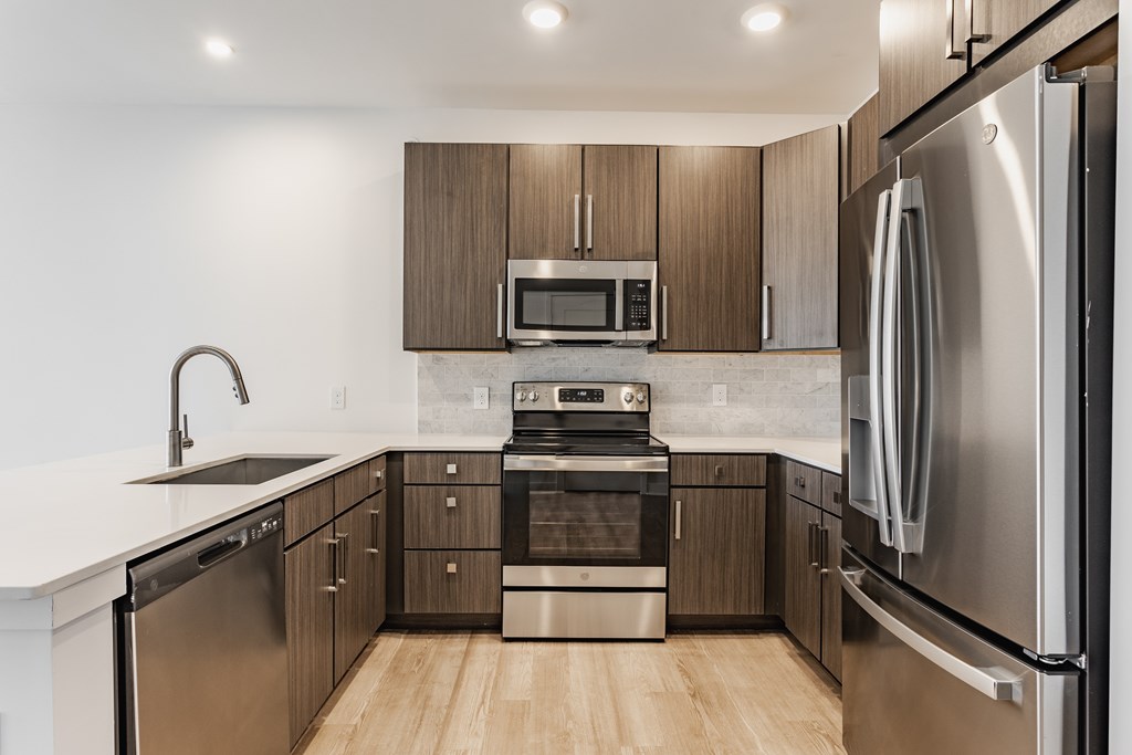 A modern kitchen with stainless steel appliances and wooden cabinets at Upper Vue Flats, Dublin
