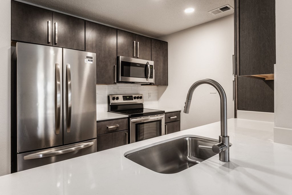 a kitchen with stainless steel appliances and a white counter top at Latitudes Apartments, Indianapolis, 46237