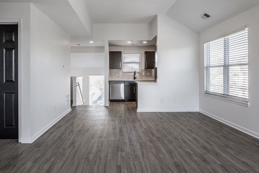 an empty living room with a kitchen in the background at Sundance Apartments, Indianapolis, IN, 46237