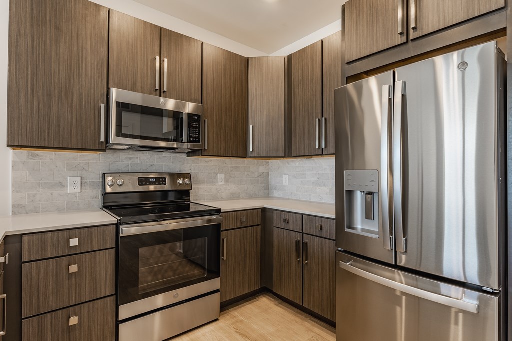 A modern kitchen with a stainless steel refrigerator and wooden cabinets at Upper Vue Flats, Dublin