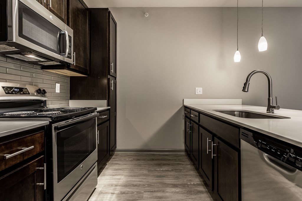 an empty kitchen with stainless steel appliances and a sink at Bella Vista Apartments, Fishers