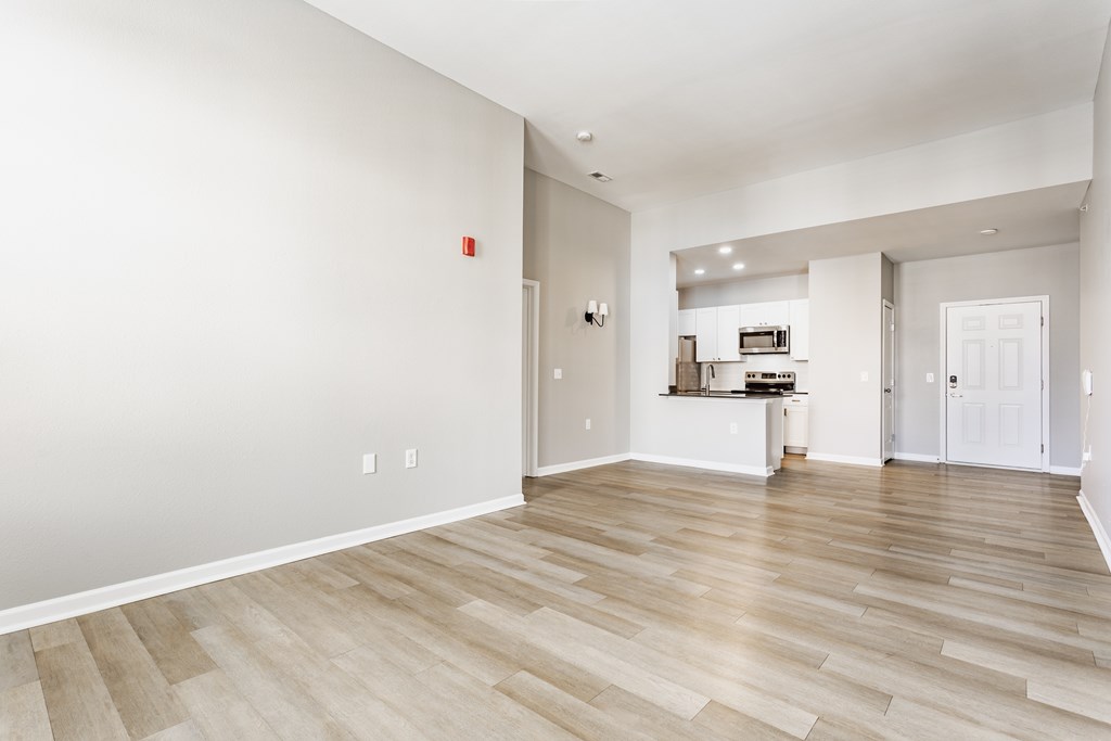 A room with wooden flooring and white walls.