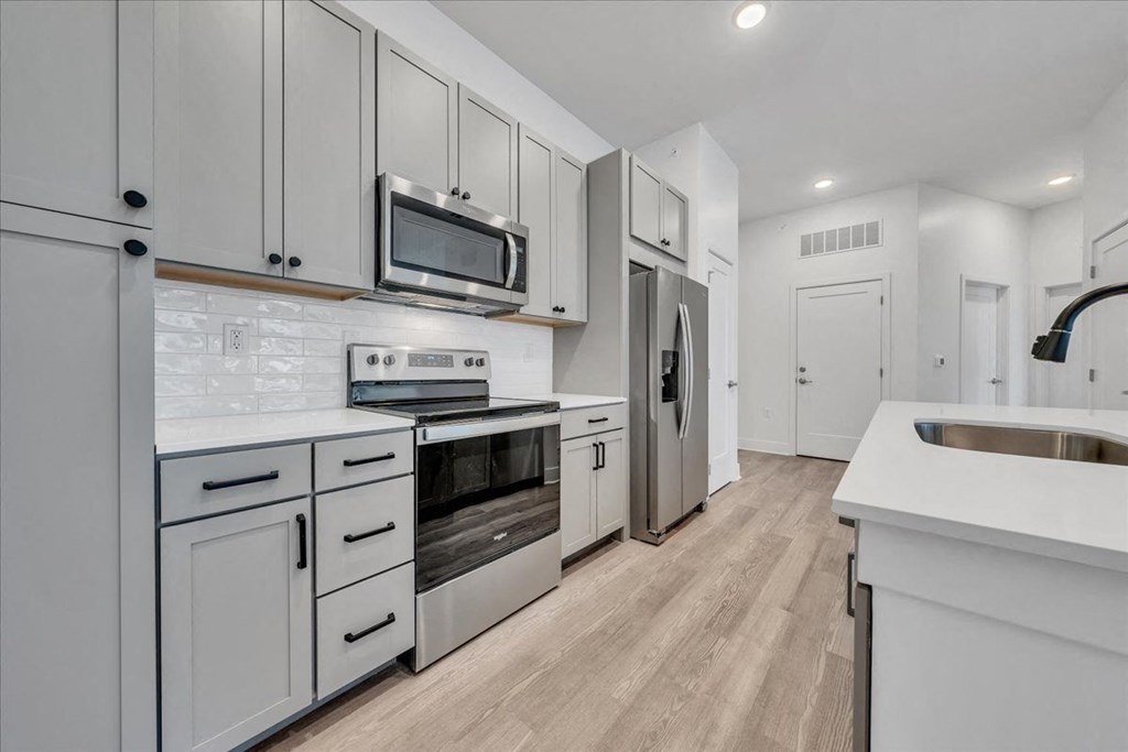 a kitchen with white cabinets and stainless steel appliances at Luxe 360 in Midlothian, Midlothian Virginia
