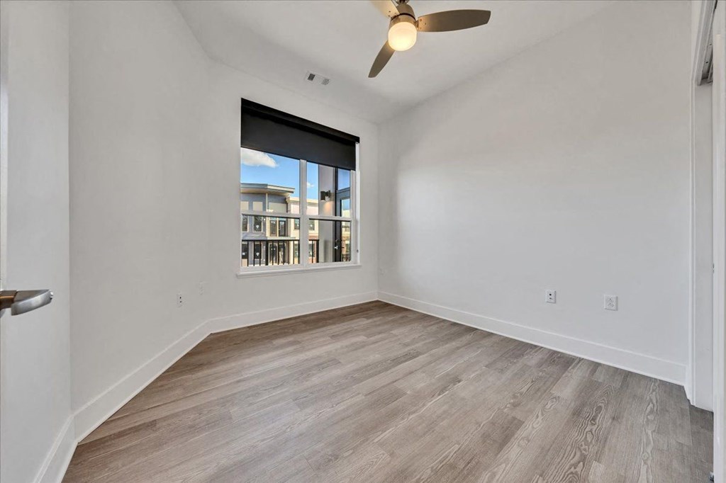 an empty living room with a window and a ceiling fan at Luxe 360 in Midlothian, Virginia