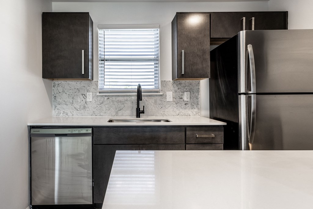 a kitchen with white countertops and dark cabinetsat Sundance Apartments, Indiana