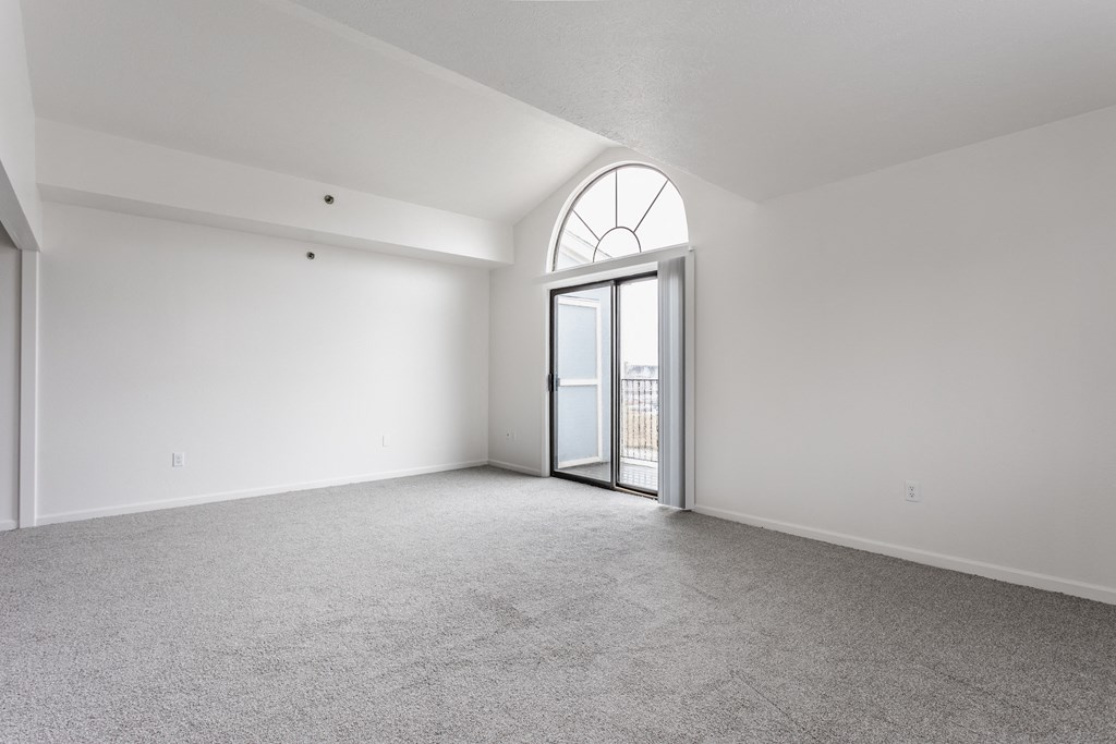 A room with a carpeted floor and a large arched window at Huntington Cove Apartments, Merrillville, IN, 46410