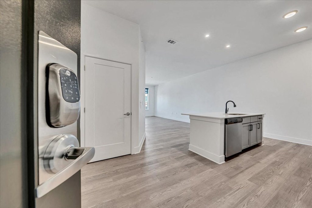 a white kitchen with a counter and a door with a door handle at Luxe 360 on Centerpointe Apartments, Midlothian, VA
