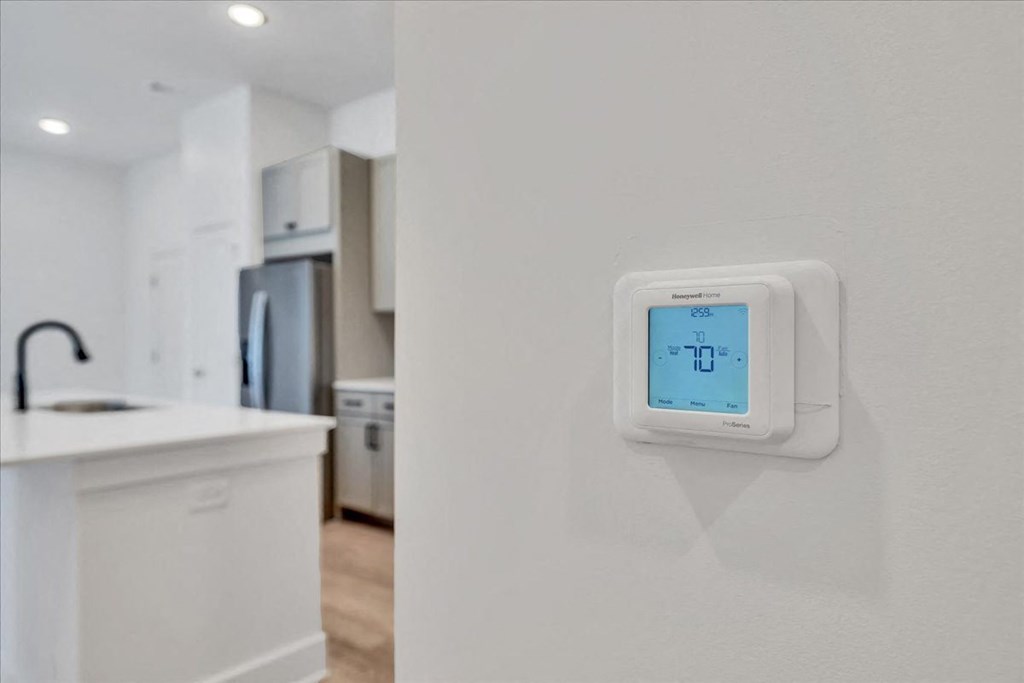a white kitchen with an electric thermostat on the wall at Luxe 360 on Centerpointe Apartments, Virginia, 23114