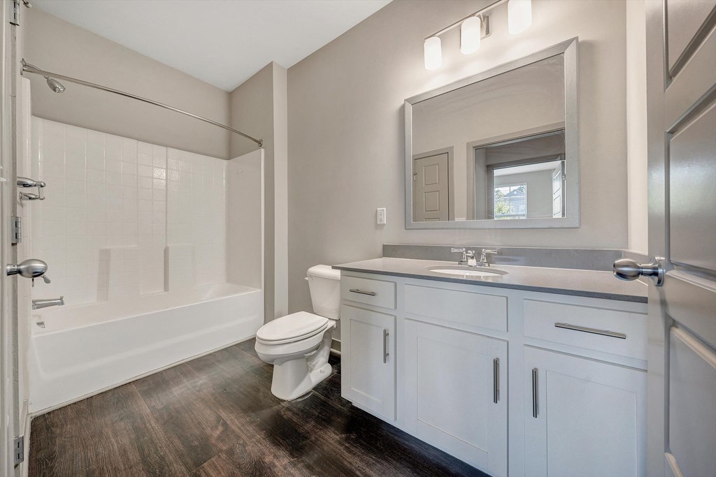 a bathroom with white cabinets and a shower and a sink and a toilet  at Avellan Springs Apartments, Morrisville, North Carolina