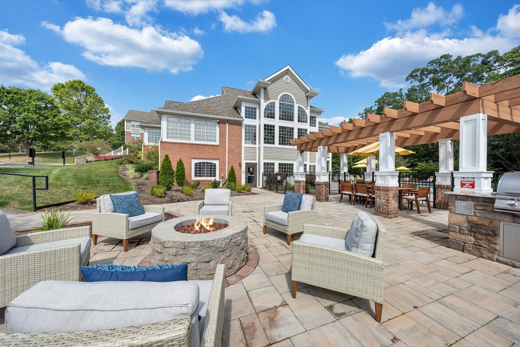 a backyard patio with chairs and a fire pit at Sunscape Apartments, Virginia