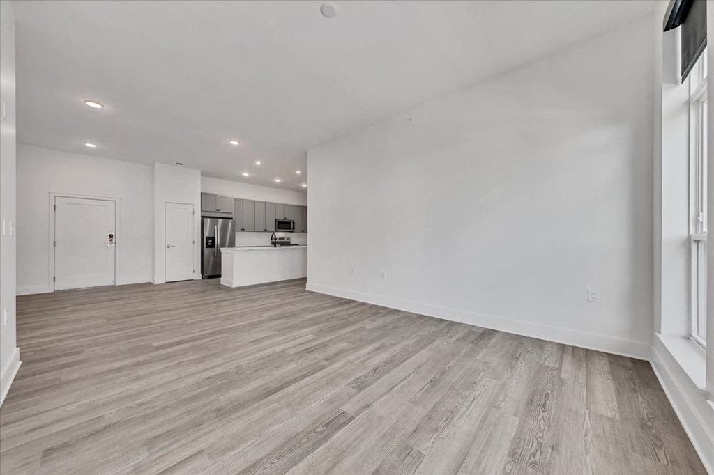 the living room and kitchen of a new home with white walls and wood flooring at Luxe 360 in Midlothian, Midlothian