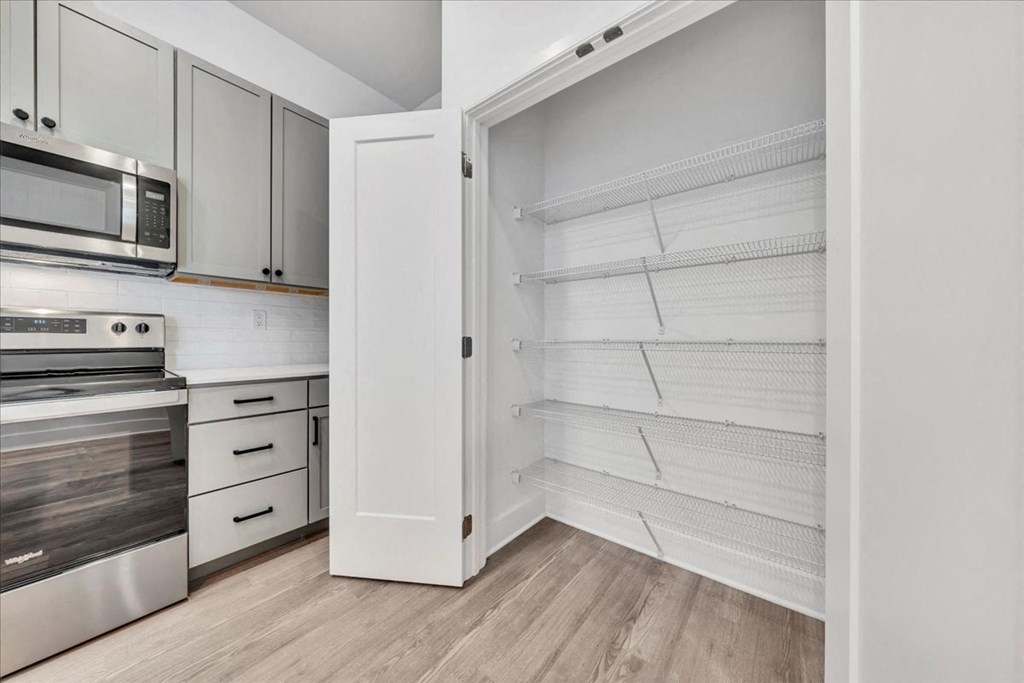 a kitchen with white cabinets and a large white closet at Luxe 360 on Centerpointe Apartments, Virginia