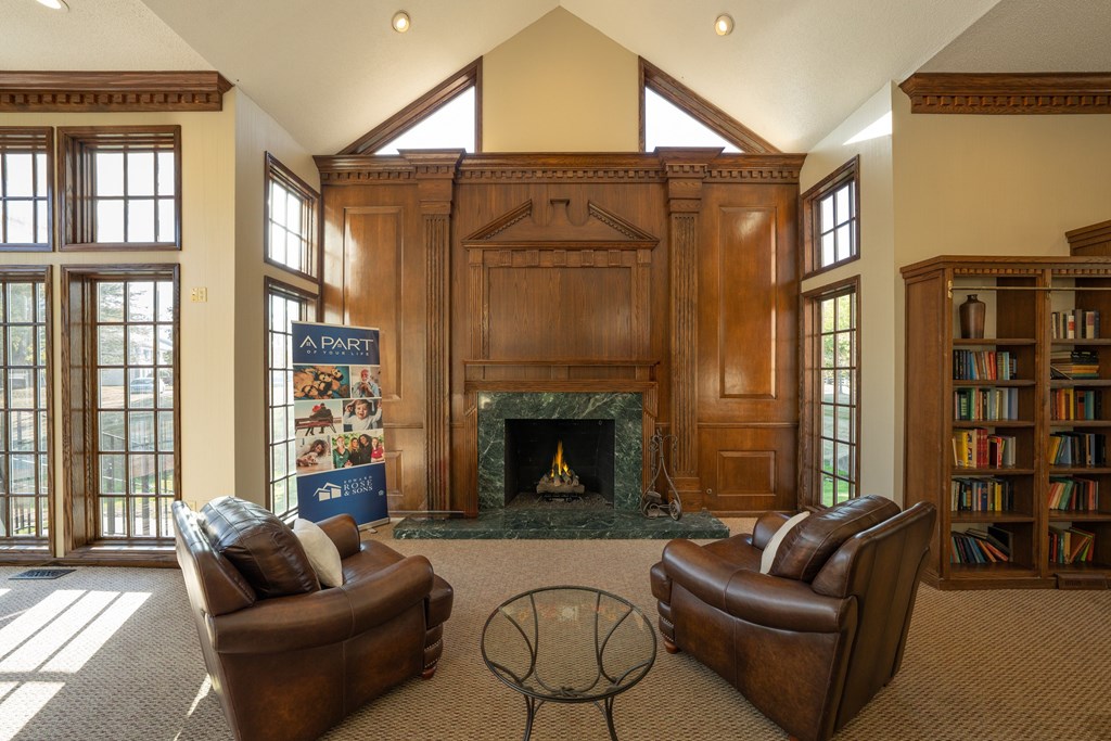 A living room with a fireplace and two leather chairs.