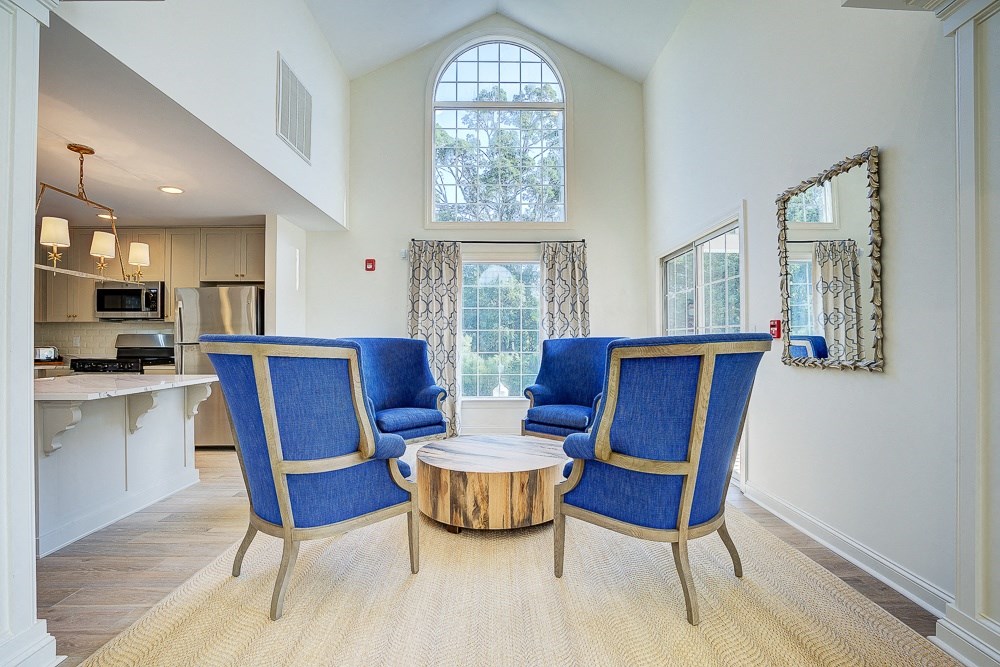 a living room with two blue chairs and a coffee table  at The Vinings Apartments, Richmond, VA