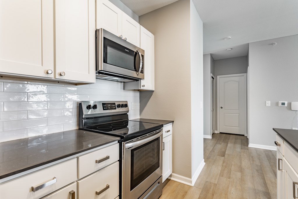 A kitchen with a stove top oven and microwave above it.