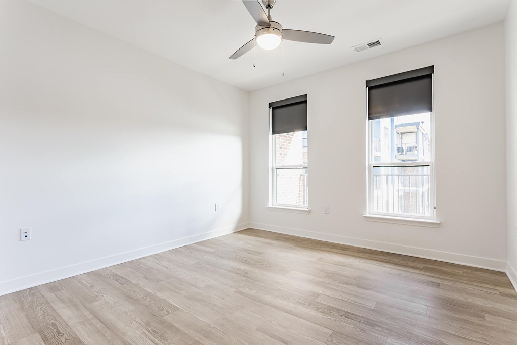 A room with a ceiling fan and two windows at Upper Vue Flats, Dublin