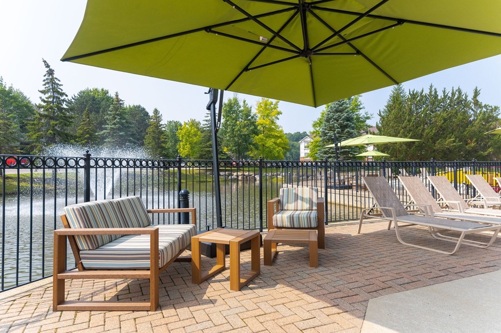 a patio with chairs and umbrellas at The Springs Apartment Homes, Michigan, 48377