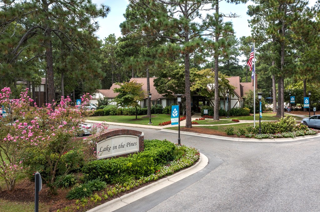 A sign that says Lake in the Pines is in front of a building.