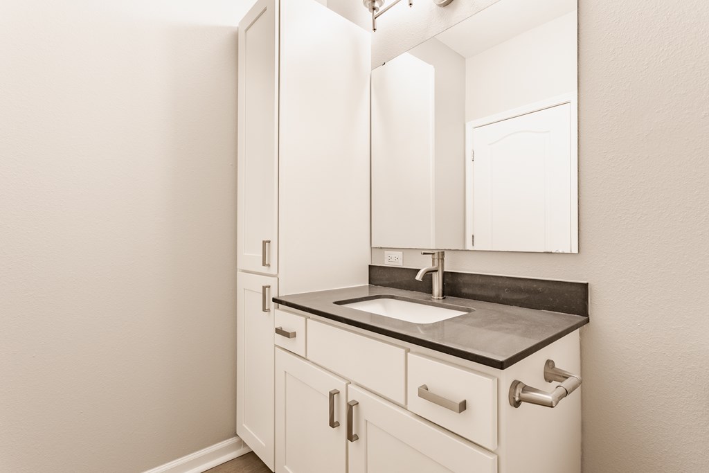 A bathroom with a sink and a mirror.
