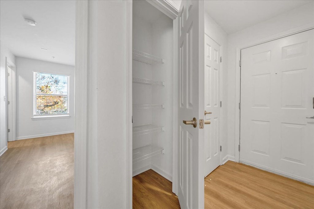 a bedroom with a closet and a window and a door at The Vinings Apartments, Virginia